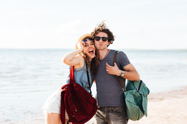 Happy hipster couple standing at the beach and hugging - Photo, image