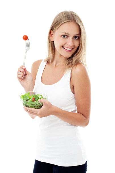 Young woman eating salad. Isolated - Фото, изображение