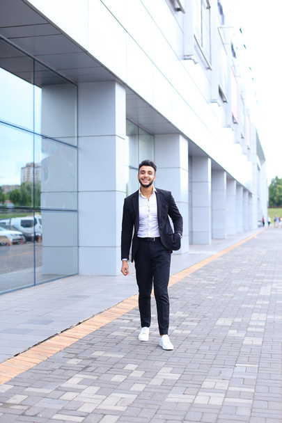 Araber im Business Center steht lächelnd und geht langsam - Foto, Bild