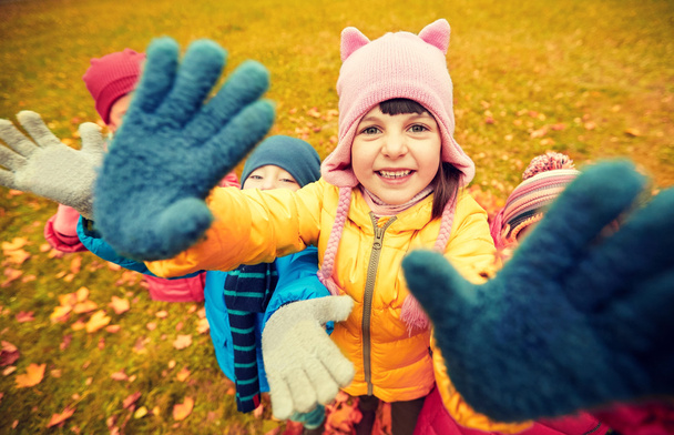 happy children waving hands in autumn park - 写真・画像