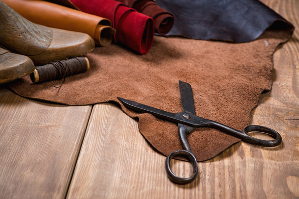 Set of leather craft tools on wooden background. Workplace for shoemaker. - Фото, зображення