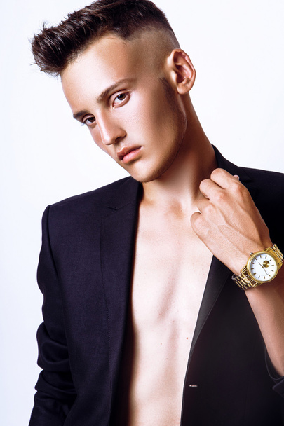 Fashion young businessman black suit casual poses at studio - 写真・画像