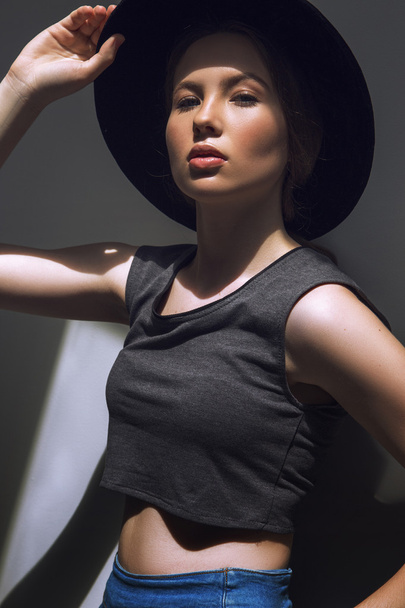 High fashion look.glamor closeup portrait of beautiful stylish Caucasian young woman model with perfect clean skin in big black hat - Fotó, kép