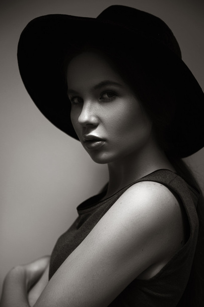 High fashion look.glamor closeup portrait of beautiful stylish Caucasian young woman model with perfect clean skin in big black hat. Black and white photo - Photo, Image
