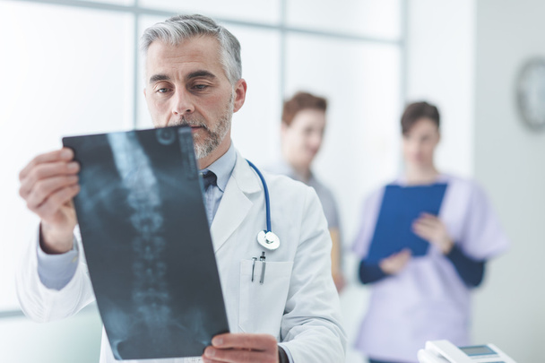Radiólogo examinando la radiografía de un paciente
 - Foto, Imagen