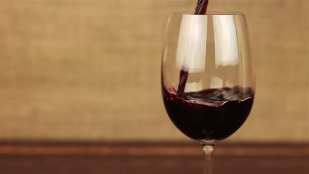 Red wine pouring into glass on wooden table - Footage, Video