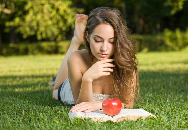 Beautiful brunette studying outdoors. - 写真・画像