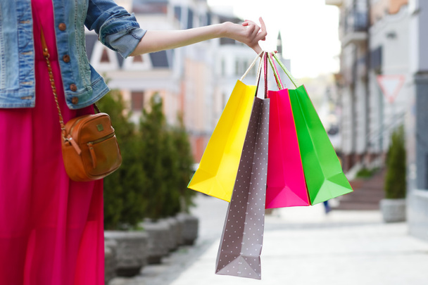closeup picture of multi colored shopping bags with a hand - Foto, afbeelding