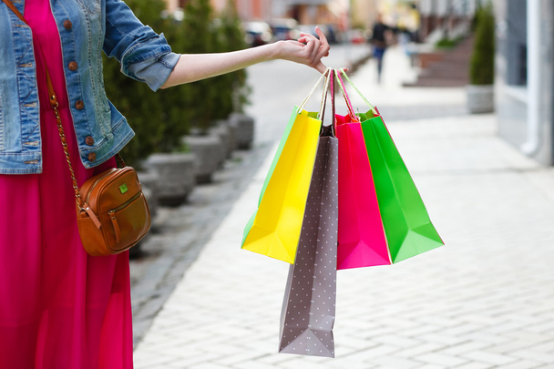 closeup picture of multi colored shopping bags with a hand - Fotografie, Obrázek