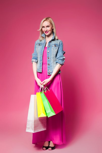 Shopping woman holding shopping bags on pink background .  - Foto, immagini