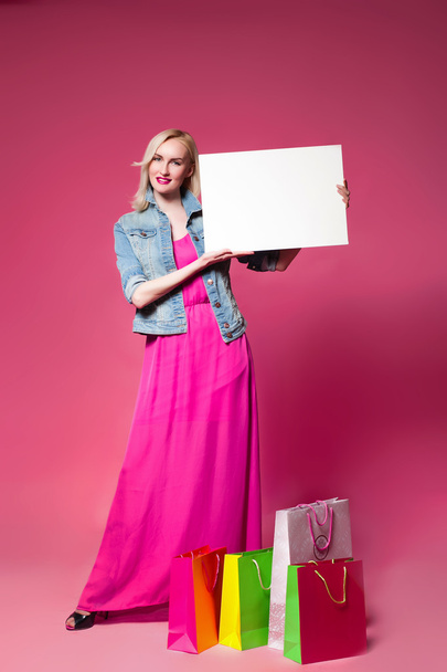 Shopping woman holding shopping bags on pink background  - Foto, Imagen