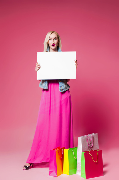 Shopping woman holding shopping bags on pink background  - Valokuva, kuva