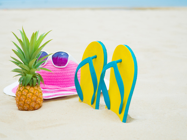ψάθινο καπέλο και γυαλιά ηλίου στην άμμο παραλία - Φωτογραφία, εικόνα