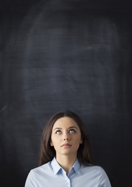 Young woman looking up with blackboard  - Fotó, kép
