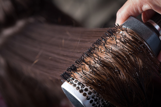 Peinar con cepillo y tira del cabello largo
 - Foto, Imagen
