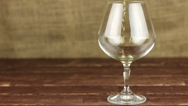 Brandy versato in un bicchiere sul tavolo di legno
 - Filmati, video
