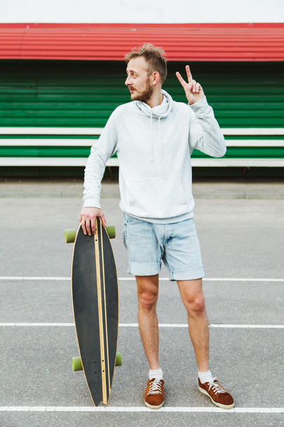 Hipster young man with longboard - Fotoğraf, Görsel