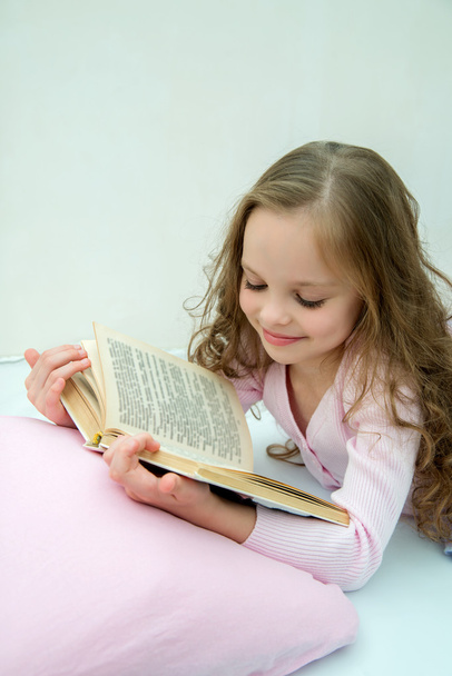 Klein meisje met verhaal boek in bed - Foto, afbeelding