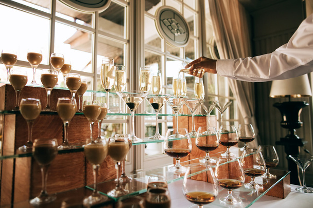 Servicio de catering. Bar de bebidas para bodas. Camarero vertiendo champán en una copa
 - Foto, imagen