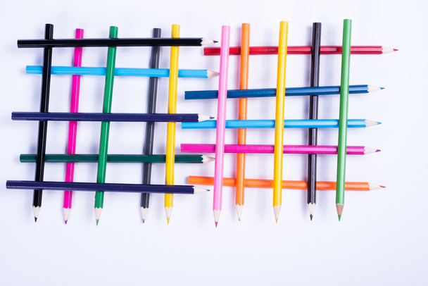 kleurrijke potloden georganiseerd in een geometrische vorm op witte CHTERGRO - Foto, afbeelding