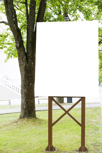 Attrappe. vertikale, leere Plakatwand mit Kopierplatz für Textnachrichten oder öffentliche Informationen. Hintergrund Stadtpark - Foto, Bild