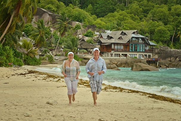 casal de idosos descansam na praia tropical
 - Foto, Imagem