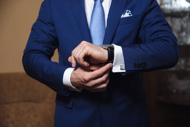 Biznesmen sprawdzania czasu na jego zegarek. męska dłoń rezygnować pewien pilnować. - Zdjęcie, obraz
