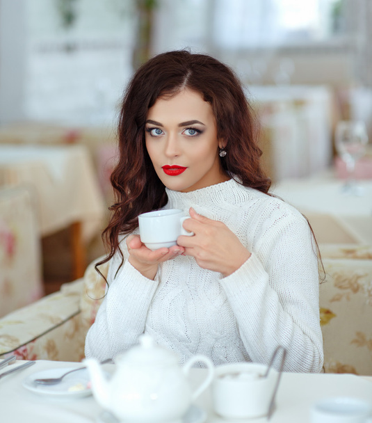 Beautiful sexy brunette girl with red lipstick in a white sweate - Photo, image