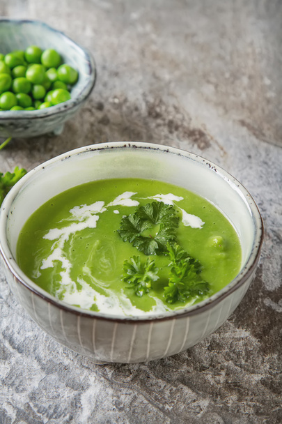 Pea soup puree in an old plate with parsley decoration. Stone sl - Foto, Bild