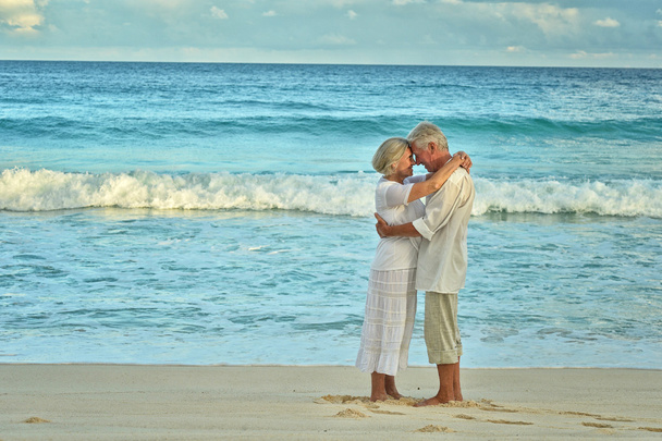 casal de idosos descansam na praia tropical
 - Foto, Imagem