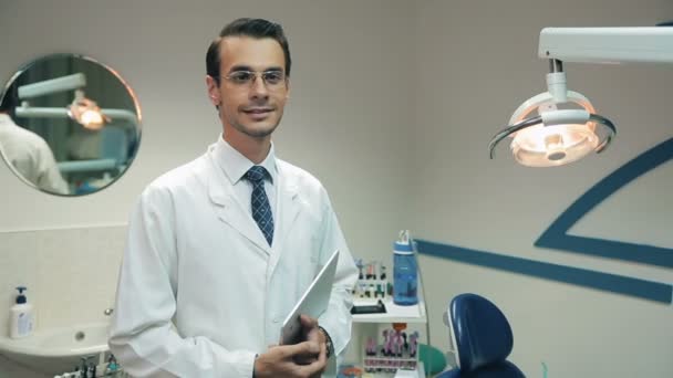 Smiling Dentist with tablet at the dental clinic - Felvétel, videó