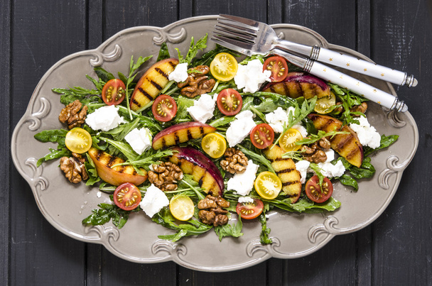 Salad with arugula and cherry tomatoes feta peaches with balsamic cream   - Photo, Image