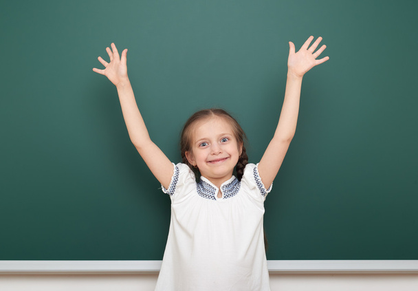 school student meisje open armen op schone blackboard, grimassen en emoties, gekleed in een zwart pak, onderwijs concept, studio foto - Foto, afbeelding