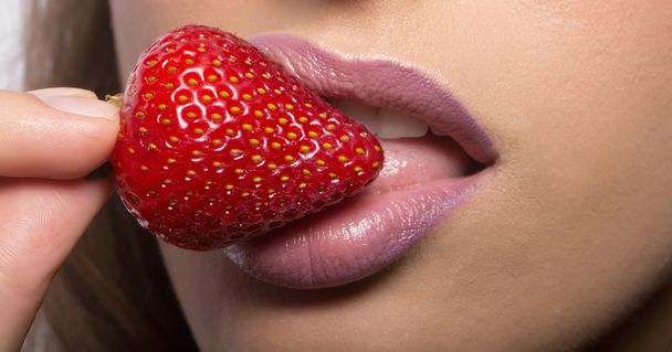 vrouwelijke lippen eten Rode aardbei - Foto, afbeelding