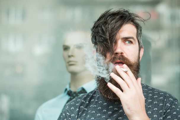 bearded man smoking near showcase - Foto, Imagen