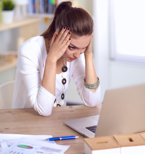 Stressed businesswoman sitting at desk - Foto, afbeelding