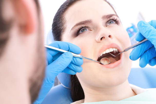Dentist examines the teeth of the patient - Фото, зображення