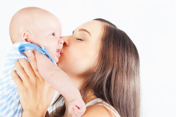 Happy mother holding a baby boy at white background - Photo, image