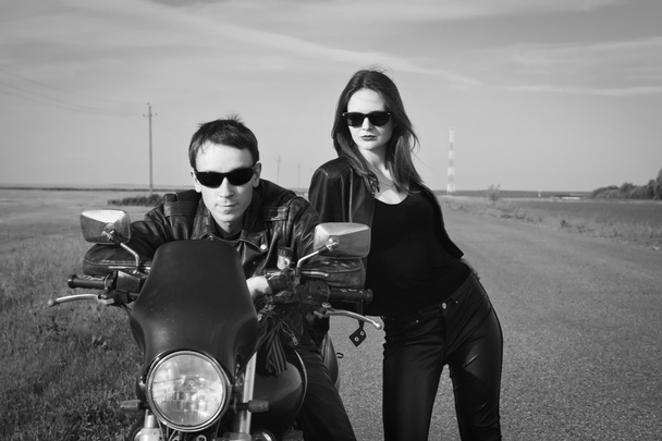 Motociclista hombre y chica se para en el camino
 - Foto, Imagen