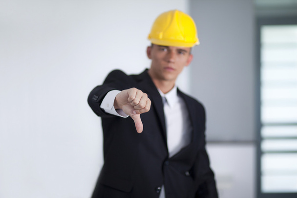 νέος επιχειρηματίας φορώντας ένα καπέλο ασφάλεια και χέρι χειρονομίες αντίχειρες - Φωτογραφία, εικόνα