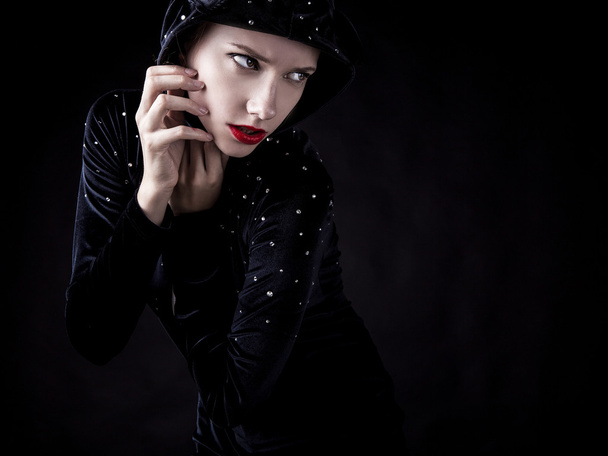 Posing woman in fashionable costume on dark background. - Photo, Image