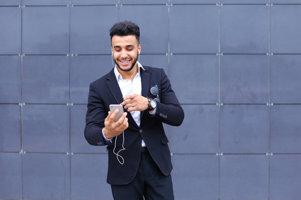 Przystojny mężczyzna arabski przyjmuje selfie inteligentny telefon w centrum biznesowe - Zdjęcie, obraz