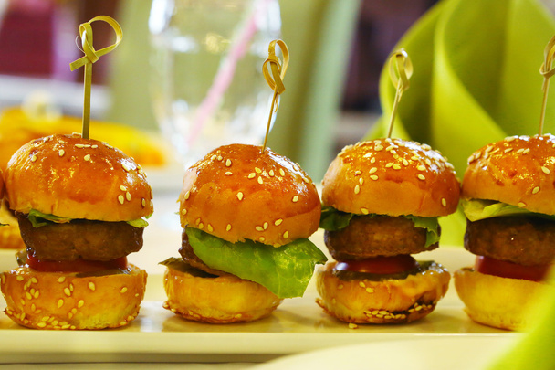 mini hambúrguer com folha de salada servida em prato
 - Foto, Imagem