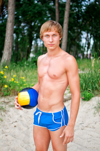 Young man posing with the ball on the beach - Photo, Image