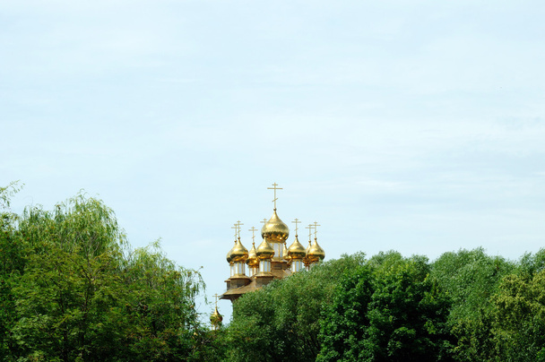 Día soleado de verano de la Santísima Trinidad. Domos dorados de la iglesia ortodoxa rusa contra el cielo azul
. - Foto, imagen