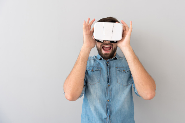 Homme barbu joyeux en utilisant un appareil de réalité virtuelle
 - Photo, image