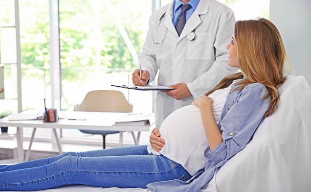 Pregnant young woman visiting doctor - Fotó, kép