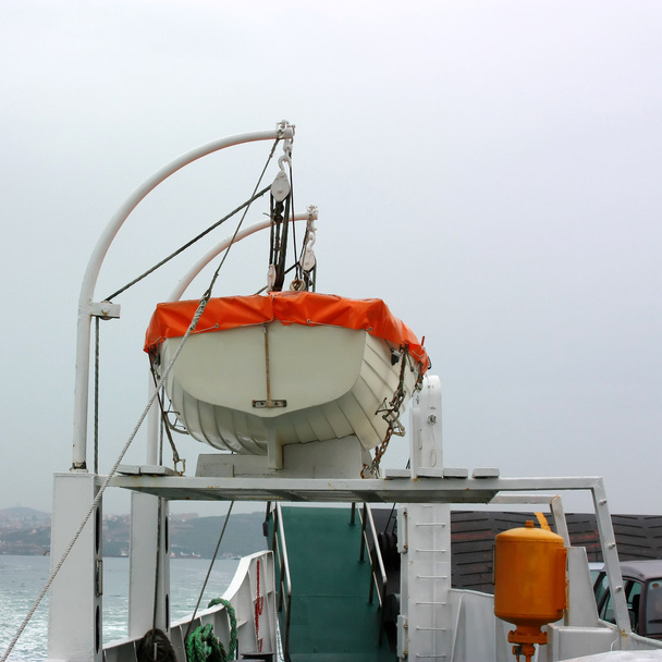 Um bote salva-vidas a ser enrolado num barco. Culturas quadradas
 - Foto, Imagem
