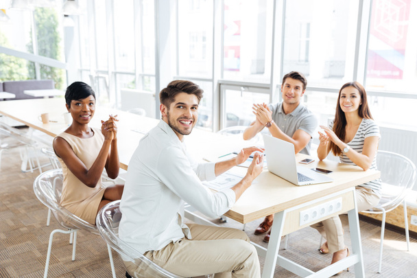 Επιχειρηματίες, κάθεται και παλαμάκια τα χέρια κατά τη διάρκεια παρουσίασης στο γραφείο - Φωτογραφία, εικόνα