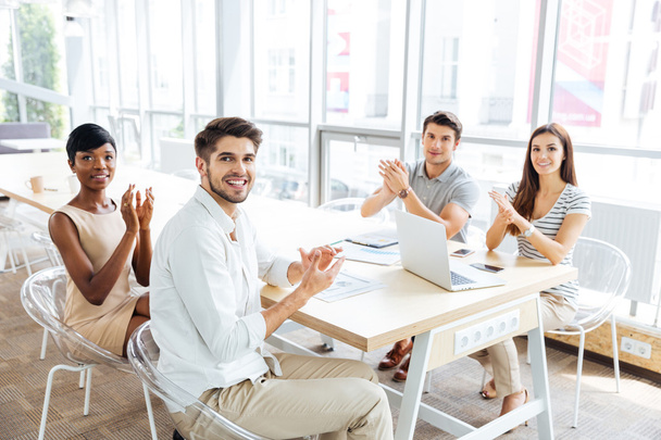 Szczęśliwy młodych biznesmenów klaskanie ręce na prezentacji w biurze - Zdjęcie, obraz